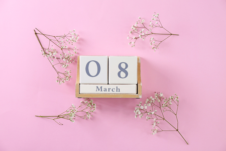 Block calendar and flowers on color background. International Women's day celebrationの写真素材
