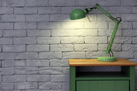 Lamp on stand near brick wallの写真素材