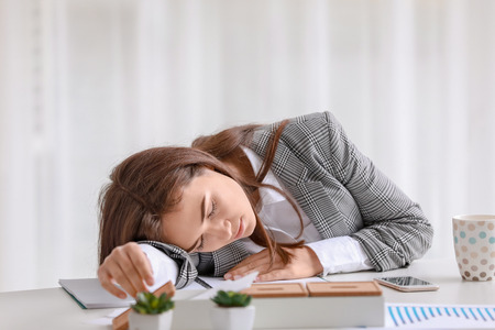 Young woman sleeping on workplaceの写真素材