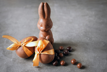 Chocolate Easter bunny, eggs and candies on tableの写真素材