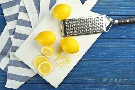 Wooden board with ripe citrus fruit on tableの写真素材