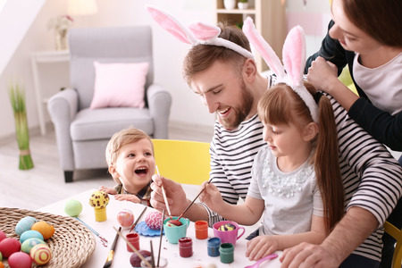Family painting Easter eggs together at tableの写真素材