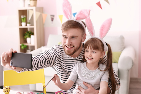 Father taking selfie with his daughter on Easterの写真素材