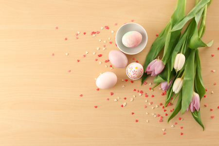Easter eggs and tulips on wooden background
