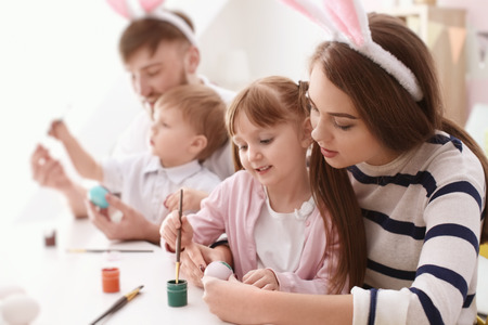 Family painting Easter eggs together at tableの写真素材