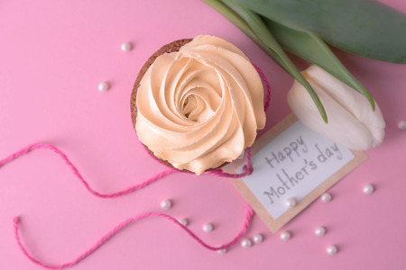 Tasty cupcake, tulip and card with words HAPPY MOTHER'S DAY on color backgroundの写真素材