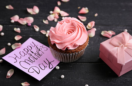 Tasty cupcake with card and gift box for Mother's day on tableの写真素材