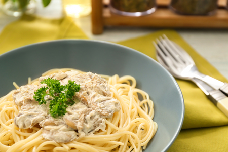Plate of delicious pasta with mushroom sauce on tableの写真素材