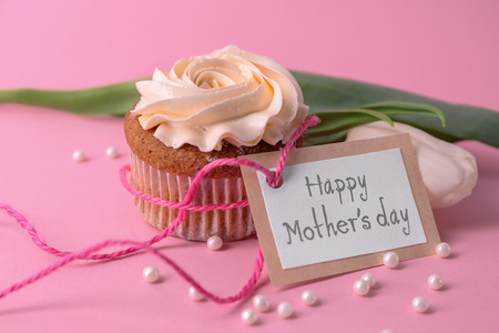 Tasty cupcake, tulip and card with words HAPPY MOTHER'S DAY on color backgroundの写真素材