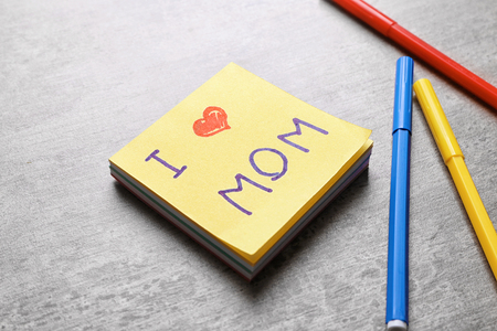 Paper note with text I LOVE MOM and felt-tip pens on table. Mother's Day celebrationの写真素材
