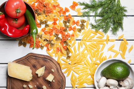 Composition with different raw pasta on wooden tableの写真素材