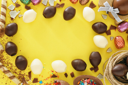 Beautiful composition with chocolate Easter eggs on color backgroundの写真素材