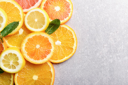 Many citrus slices on gray background, top viewの写真素材