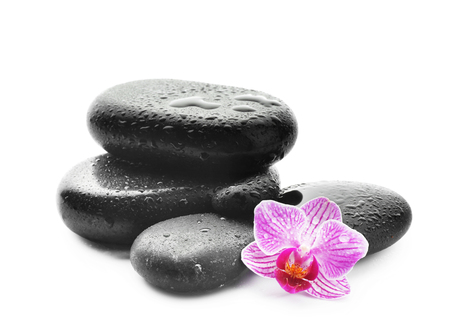 Spa stones with drops of water and beautiful flower on white backgroundの写真素材