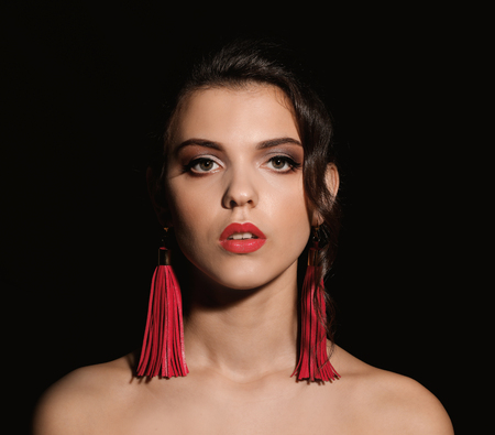 Portrait of young woman with beautiful professional makeup on dark backgroundの写真素材