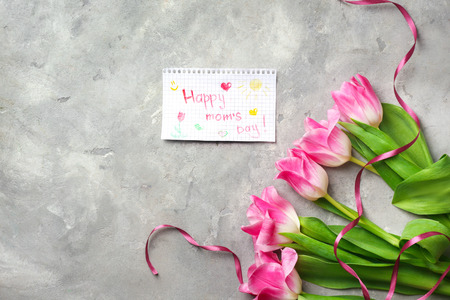 Beautiful tulips and handmade card for Mother's Day on grey textured background, top viewの写真素材