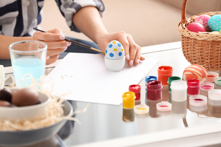 Beautiful young woman painting Easter egg at home, closeupの写真素材