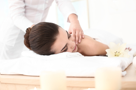 Young woman enjoying massage in spa salonの写真素材