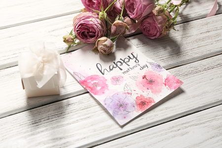 Gift box, flowers and card with words HAPPY MOTHER'S DAY on wooden backgroundの写真素材