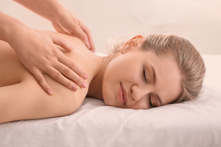 Young woman having back massage in beauty salonの写真素材