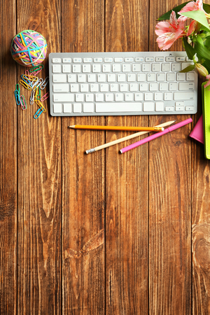 Computer keyboard, flowers and stationery on table, flat lay. Workplace compositionの写真素材