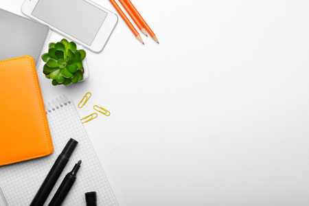 Workplace table composition with stationery and mobile phone on white backgroundの写真素材