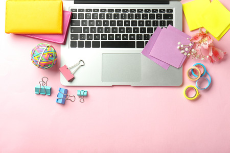 Laptop and stationery on color background, flat lay. Workplace table compositionの写真素材