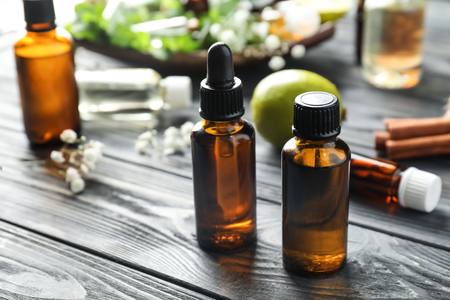 Bottles with citrus essential oil on wooden tableの写真素材