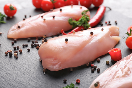 Raw chicken fillet with spices on slate plate, closeupの写真素材