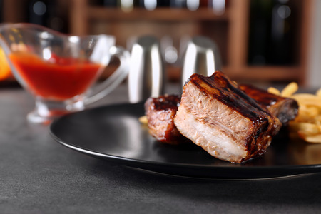Plate with delicious grilled ribs on tableの写真素材