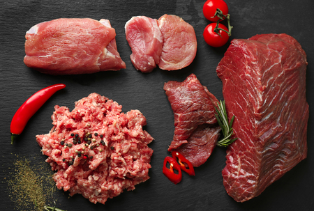 Composition with different sorts of fresh meat on dark backgroundの写真素材
