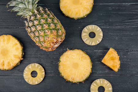 Composition with fresh pineapples on dark wooden backgroundの写真素材