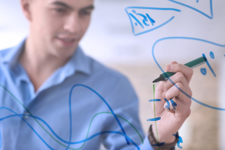 Young man giving presentation during business meeting in officeの写真素材