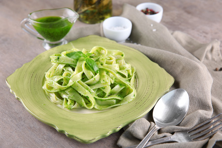 Plate of delicious pasta with pesto sauce on tableの写真素材