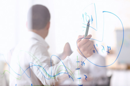 Young man giving presentation during business meeting in officeの写真素材