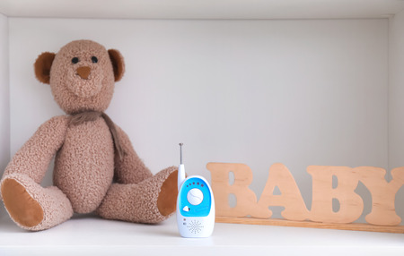 Baby monitor, toy and wooden letters on shelfの写真素材
