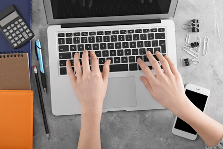 Young woman working with laptop at table, top view. Modern workplaceの写真素材