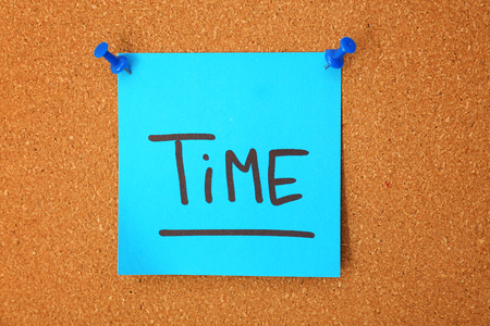 Sticker paper with word TIME on cork backgroundの写真素材