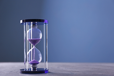 Stylish hourglass on color background. Time management concept