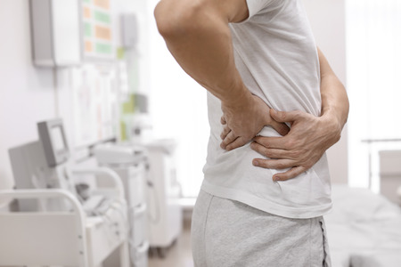 Man suffering from flank pain in orthopedist's officeの写真素材