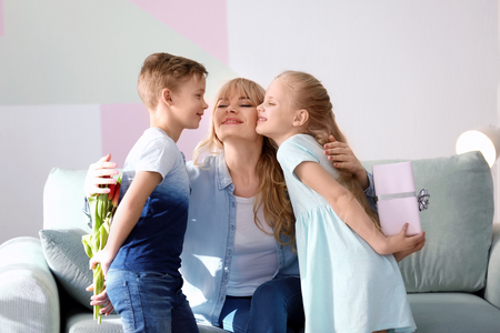 Cute little kids congratulating their mother at homeの写真素材
