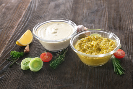 Tasty sauces in bowls on wooden tableの写真素材