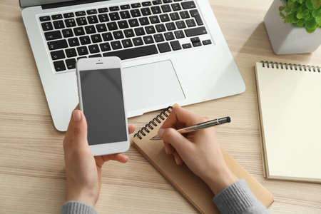 Young woman using mobile phone for online food deliveryの写真素材