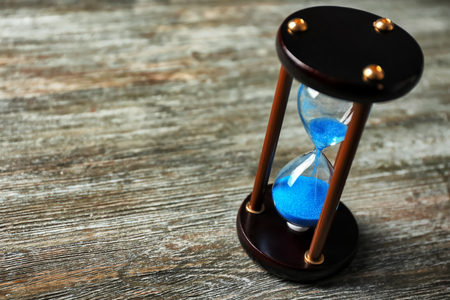 Crystal hourglass on wooden background. Time management concept