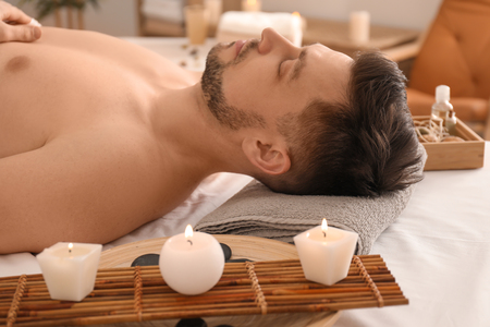 Handsome man relaxing in spa salonの写真素材