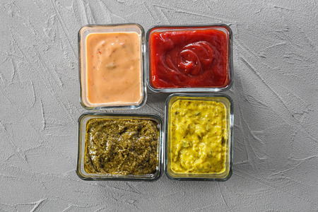 Different tasty sauces in bowls on grey backgroundの写真素材