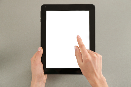 Young woman using tablet computer on grey backgroundの写真素材