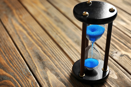 Crystal hourglass on wooden background. Time management concept