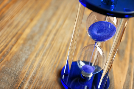 Crystal hourglass on wooden background. Time management concept