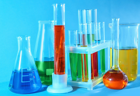 Chemical glassware with colorful samples on color backgroundの写真素材